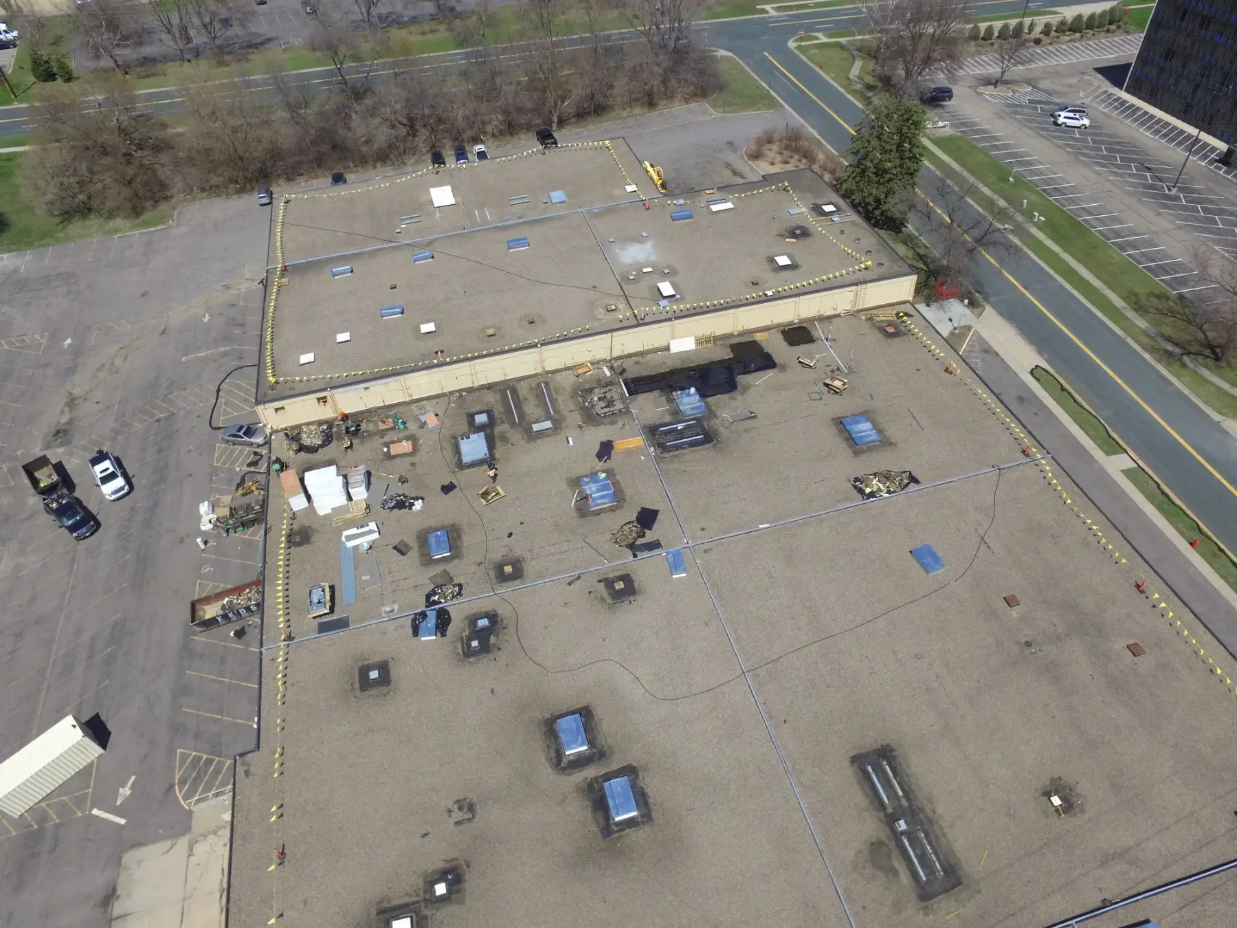 Commercial flat roof mid-project with materials staged across the deck