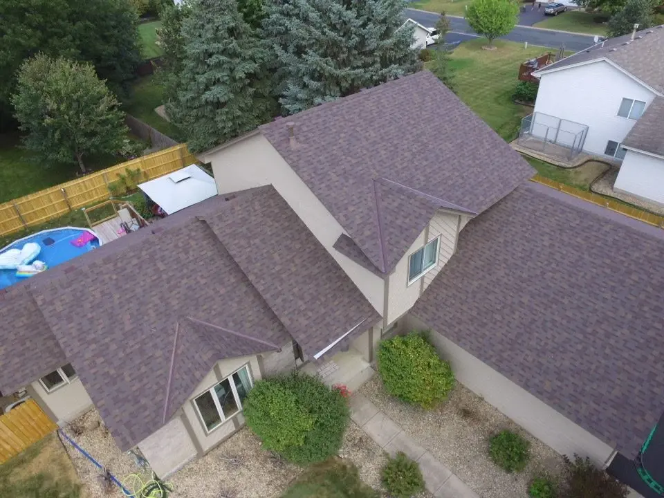 Completed multi-tone shingle roof on a suburban home, seen from above