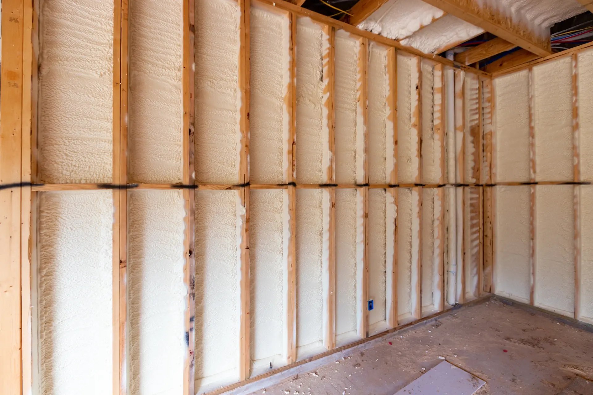 Spray foam insulation filling the stud cavities of an interior wall