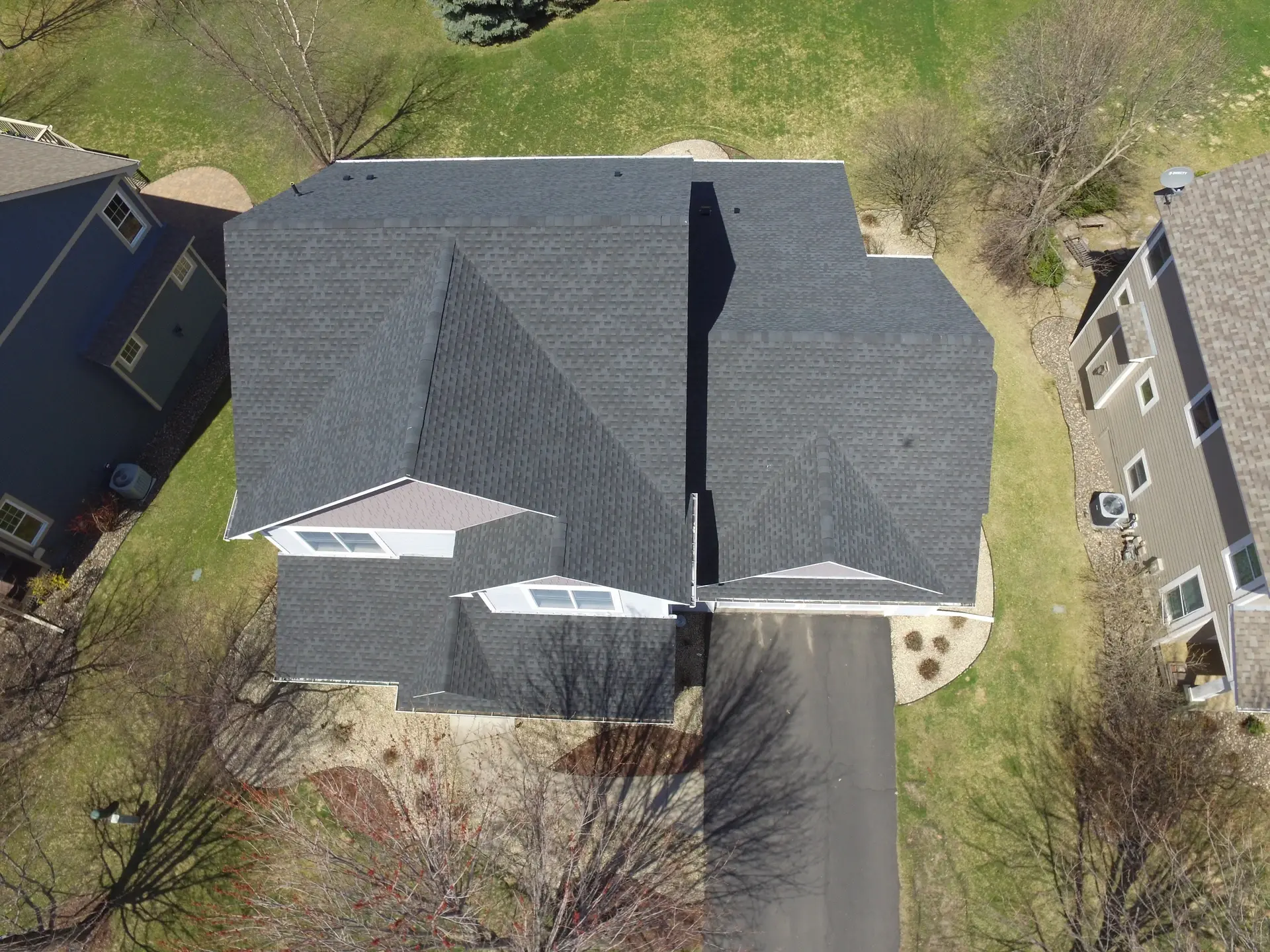 Aerial view of a dark gray asphalt shingle roof on a two-story home