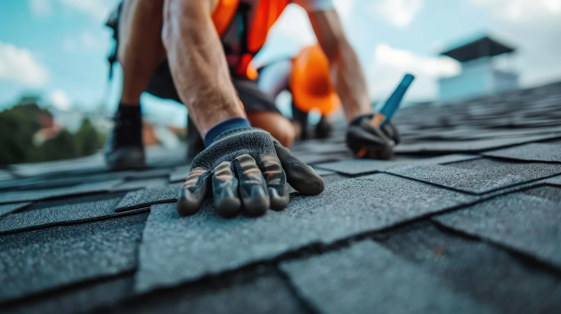Roofer in work gloves pressing down a replacement asphalt shingle