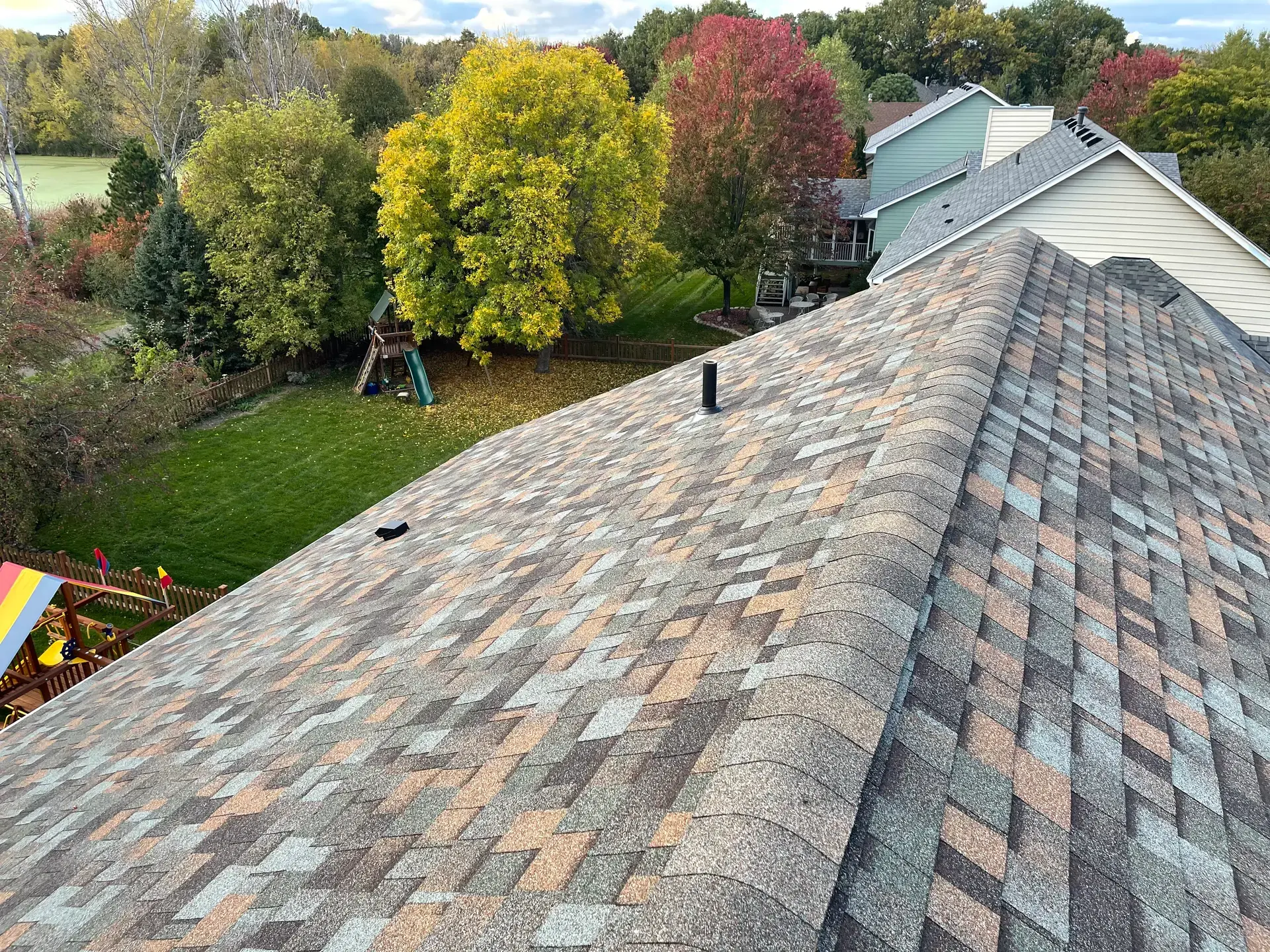 View along the ridge of a weathered multi-tone asphalt shingle roof