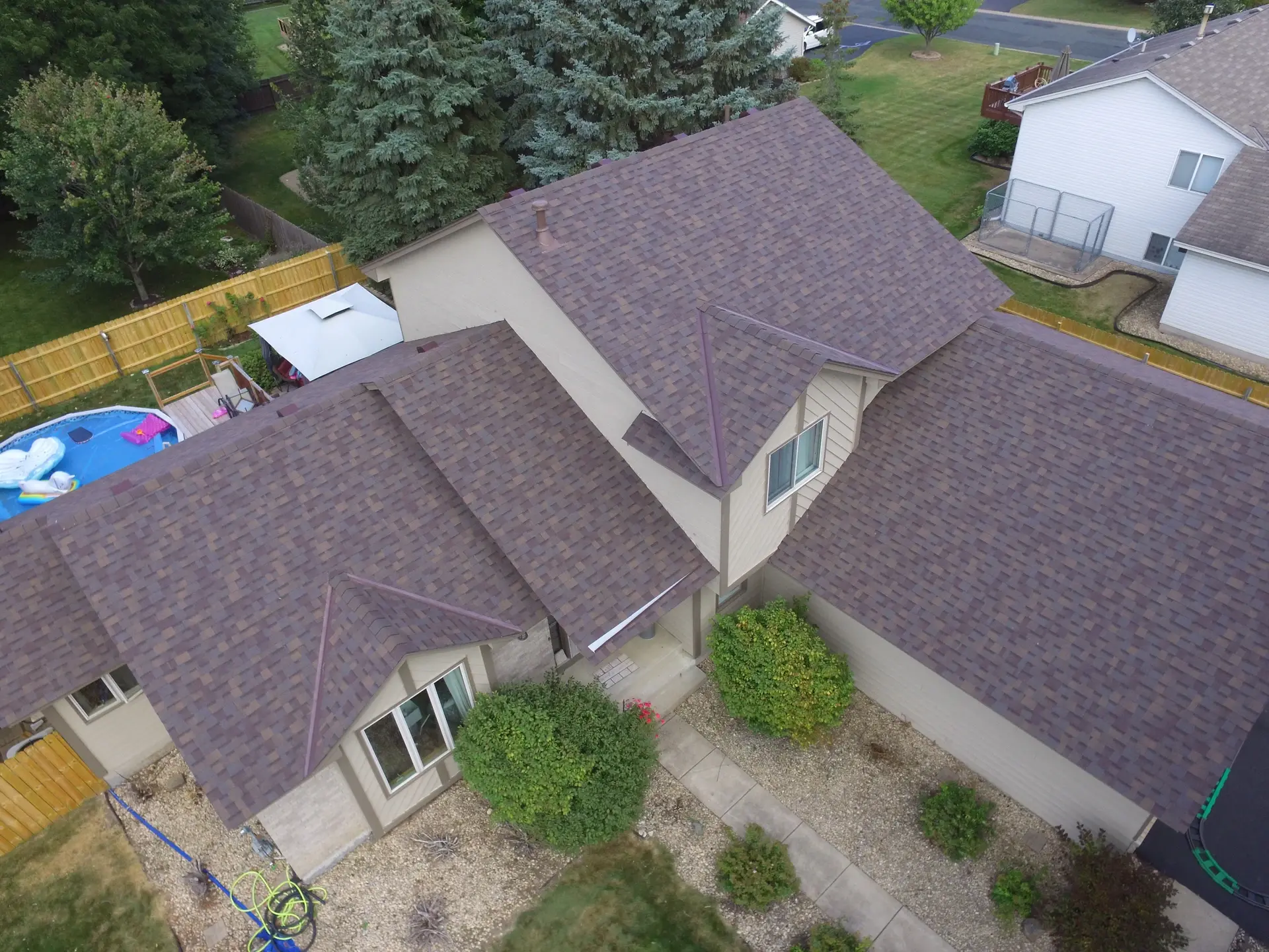 Aerial view of a home with a brown asphalt shingle roof across several rooflines